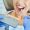 Male dentist and woman in dental clinic choosing implant shade